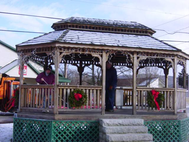 gazebo with wreaths and snow on roof